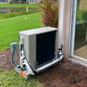 Mini-split outdoor unit installation next to a sliding glass door